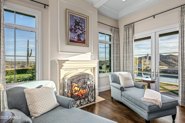 sitting room with ornamental molding, dark hardwood / wood-style flooring, a wealth of natural light, and beamed ceiling