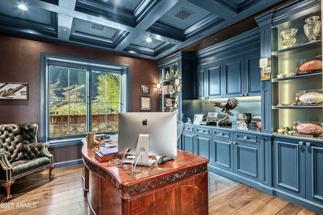 home office with beam ceiling, light hardwood / wood-style flooring, coffered ceiling, and crown molding