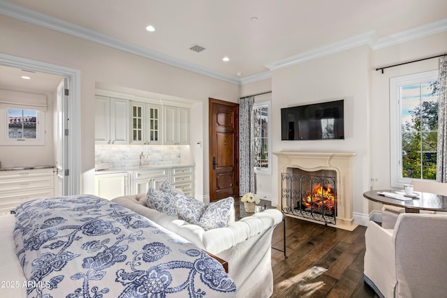 bedroom with ornamental molding, sink, and dark hardwood / wood-style floors