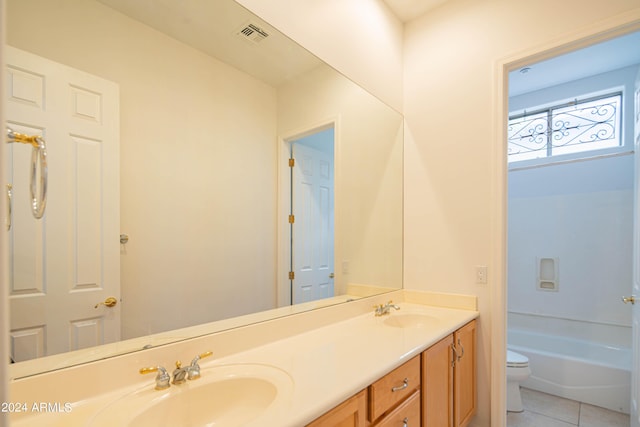 bathroom featuring double vanity, tile patterned flooring, toilet, and a sink