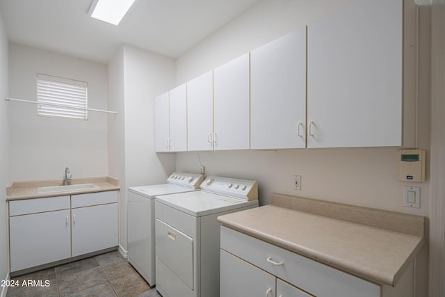 laundry area with cabinet space, washer and clothes dryer, and a sink