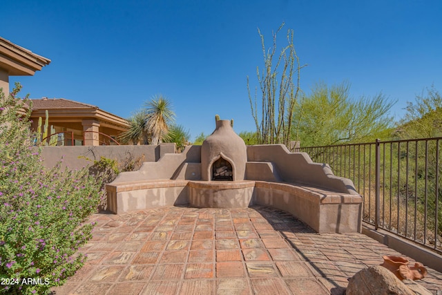 view of patio / terrace with fence and exterior fireplace