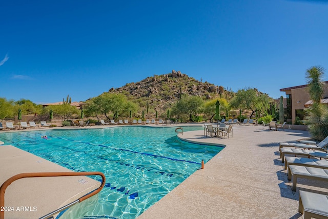 view of swimming pool with a mountain view and a patio