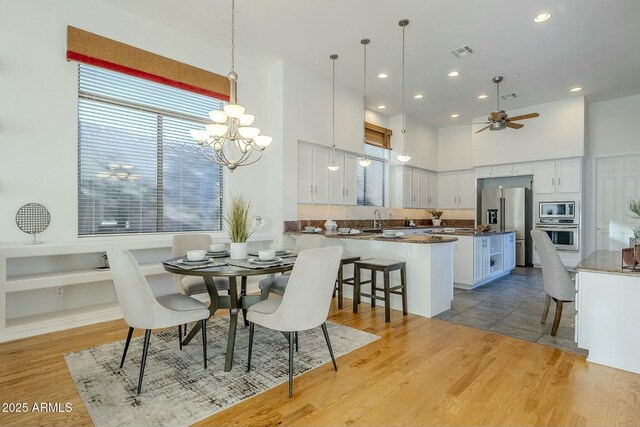 unfurnished living room featuring built in shelves, a tiled fireplace, hardwood / wood-style floors, and ceiling fan