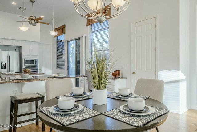 unfurnished living room featuring ceiling fan with notable chandelier, light hardwood / wood-style flooring, built in features, and a fireplace