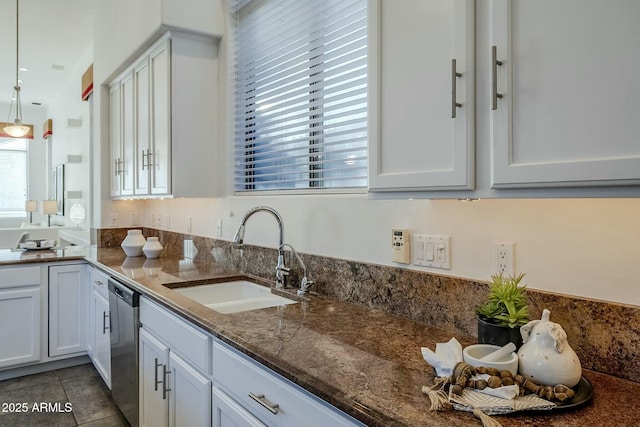 kitchen featuring hanging light fixtures, a sink, and white cabinetry