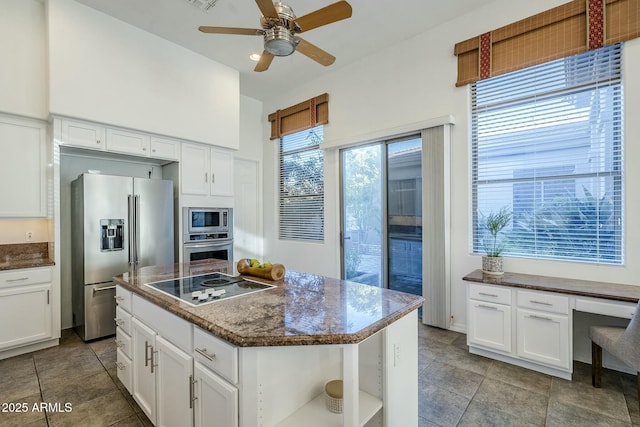 kitchen with white cabinets, built in study area, a center island, stainless steel appliances, and open shelves