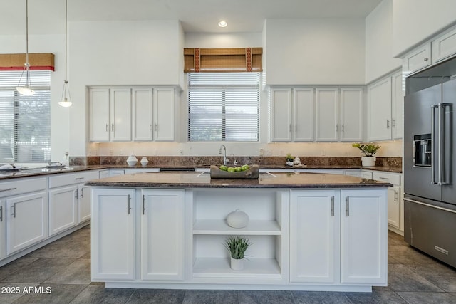 kitchen featuring white cabinets, high quality fridge, open shelves, and a center island