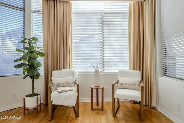 sitting room with baseboards and light wood-style floors