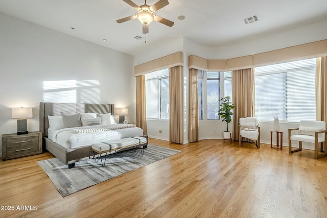 bedroom with light wood-style flooring, visible vents, and baseboards