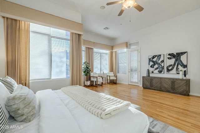 bedroom with baseboards, ceiling fan, visible vents, and wood finished floors