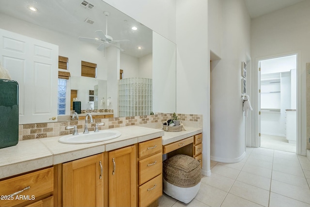 full bathroom with visible vents, a towering ceiling, tile patterned floors, vanity, and backsplash