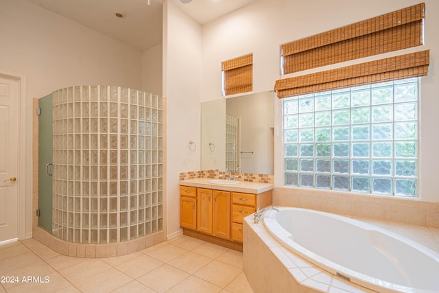 full bathroom with a healthy amount of sunlight, a stall shower, tile patterned floors, and vanity