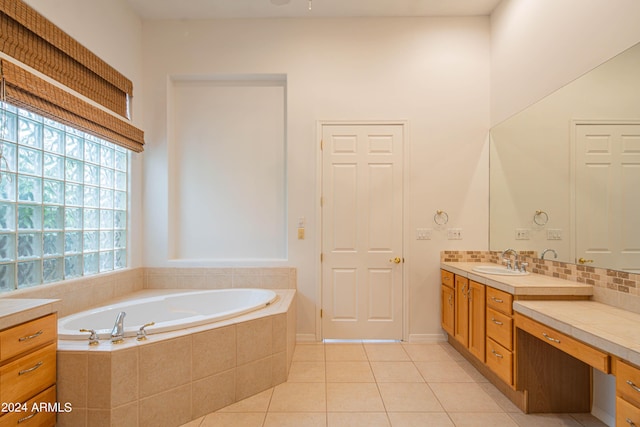 bathroom with tasteful backsplash, a garden tub, vanity, and tile patterned floors