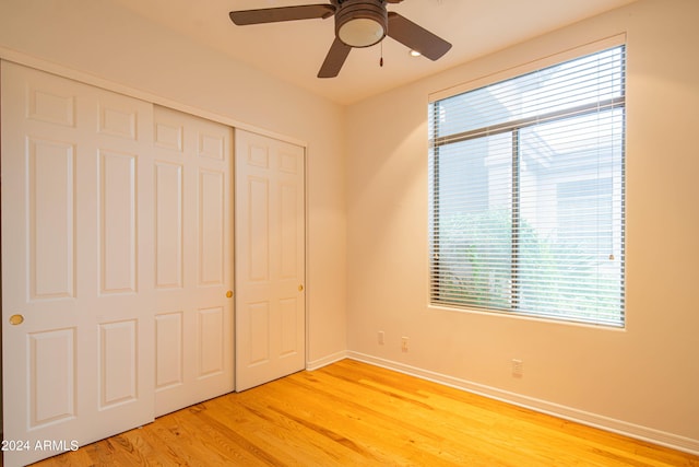 unfurnished bedroom featuring baseboards, a closet, a ceiling fan, and light wood-style floors