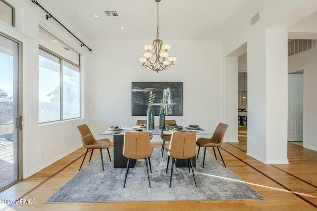 empty room featuring ceiling fan with notable chandelier and light hardwood / wood-style flooring