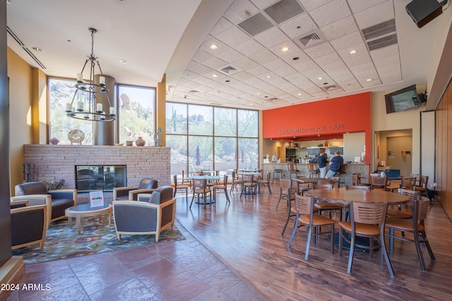 dining area featuring visible vents, a glass covered fireplace, expansive windows, a notable chandelier, and recessed lighting