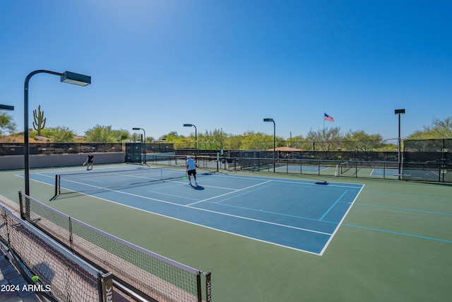 view of tennis court featuring fence