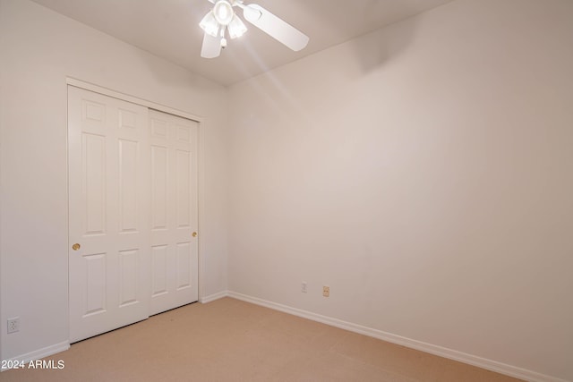 unfurnished bedroom with a ceiling fan, a closet, light colored carpet, and baseboards