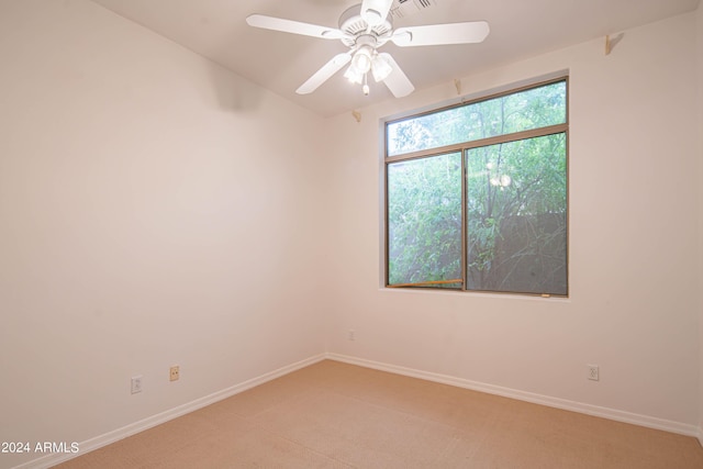 unfurnished room featuring a ceiling fan, light carpet, and baseboards