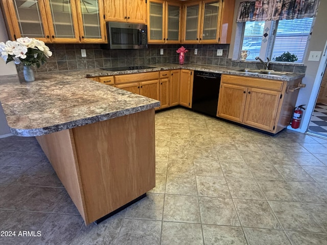 kitchen featuring glass insert cabinets, a peninsula, black appliances, a sink, and backsplash