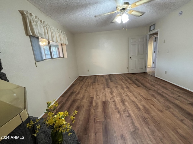 empty room with visible vents, baseboards, a ceiling fan, a textured ceiling, and wood finished floors