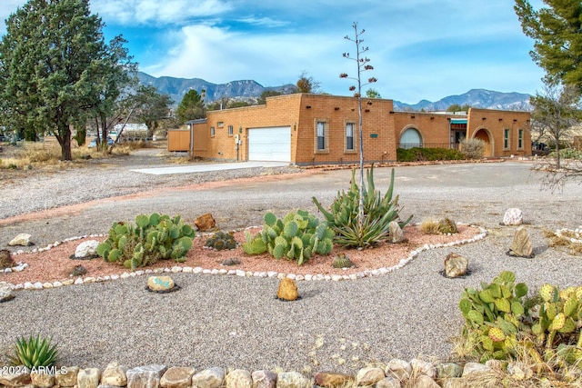 exterior space with driveway, a mountain view, and an attached garage