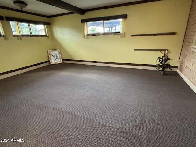 carpeted empty room with baseboards and beamed ceiling