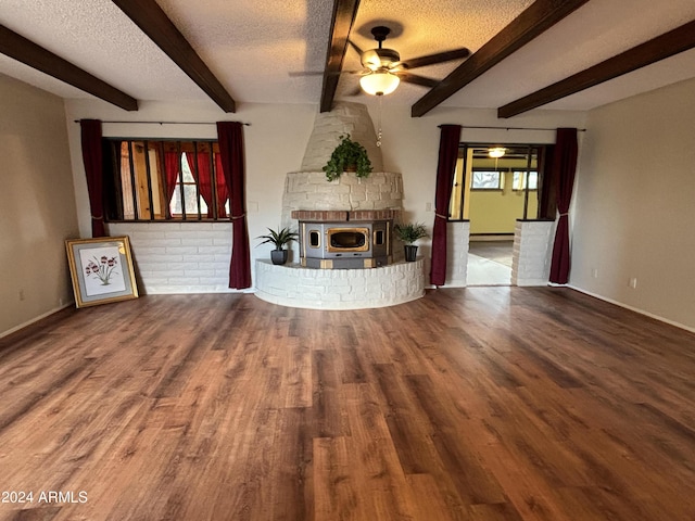 unfurnished living room with a textured ceiling, wood finished floors, beam ceiling, and ceiling fan