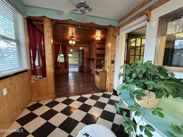hall featuring wooden walls and tile patterned floors