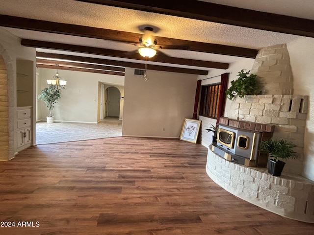 unfurnished living room with visible vents, arched walkways, a textured ceiling, wood finished floors, and ceiling fan with notable chandelier
