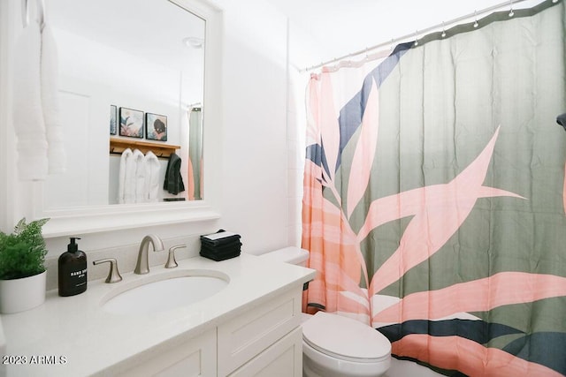 bathroom with toilet, vanity, and a shower with curtain