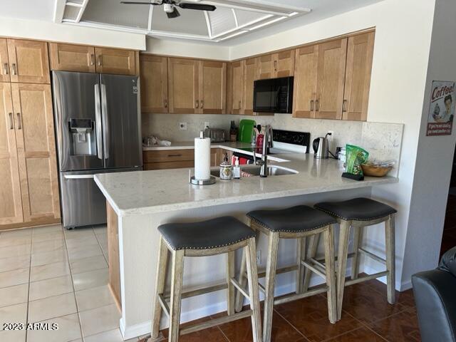 6122 E Saddleback St, Mesa, AZ 85215 - kitchen featuring a ceiling fan, black microwave, a sink, a peninsula, and stainless steel fridge