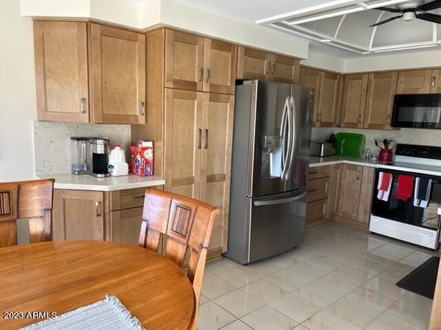 6122 E Saddleback St, Mesa, AZ 85215 - kitchen with black microwave, electric range oven, light countertops, light tile patterned floors, and stainless steel fridge