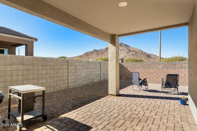 view of patio with a mountain view and a fenced backyard