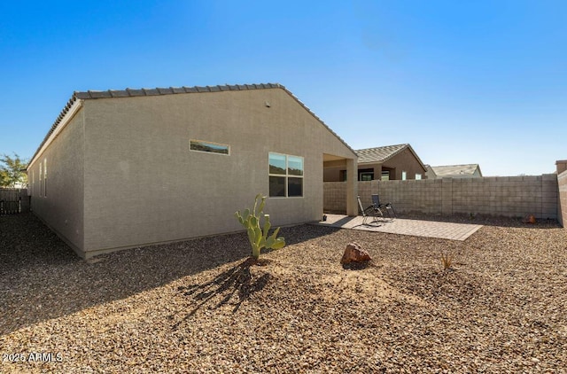 back of house with stucco siding, a patio, and fence