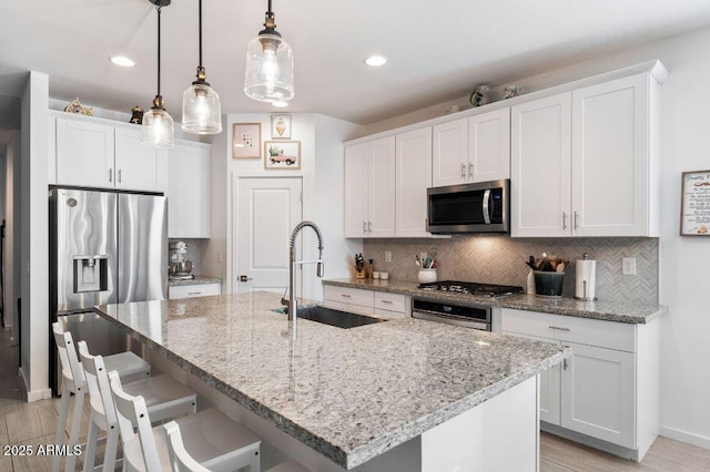 kitchen featuring decorative backsplash, appliances with stainless steel finishes, and a sink