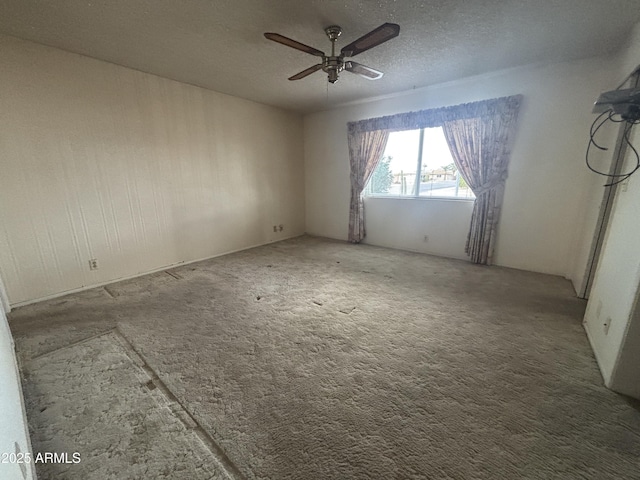 carpeted spare room with ceiling fan and a textured ceiling