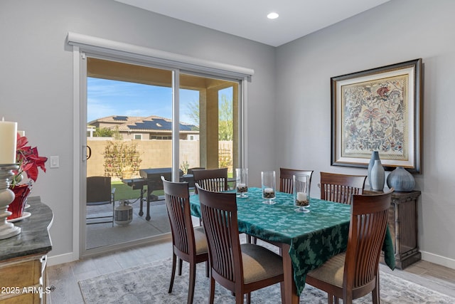 dining room with recessed lighting, baseboards, and light wood-type flooring