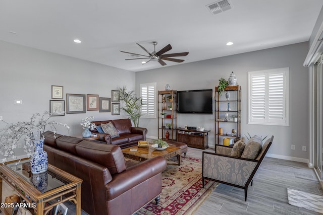 living room featuring wood finished floors, a ceiling fan, visible vents, baseboards, and recessed lighting
