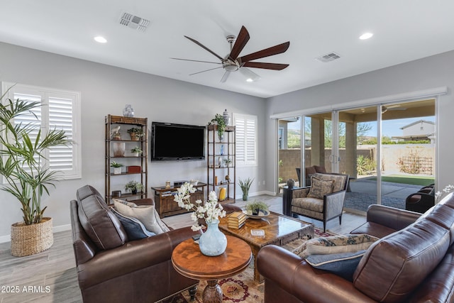 living room featuring visible vents, plenty of natural light, and ceiling fan