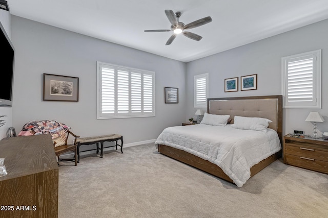 bedroom featuring baseboards, light colored carpet, and a ceiling fan
