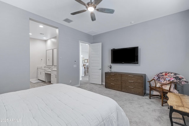 bedroom featuring ensuite bath, baseboards, visible vents, and light carpet