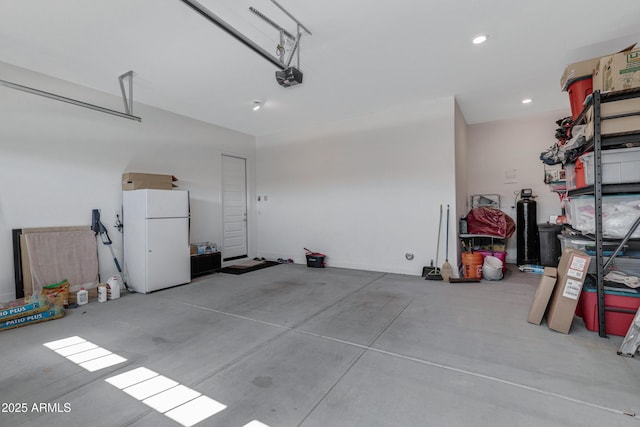 garage with recessed lighting, a garage door opener, and freestanding refrigerator