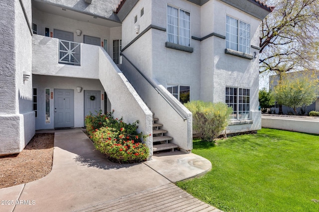 property entrance with stucco siding and a yard