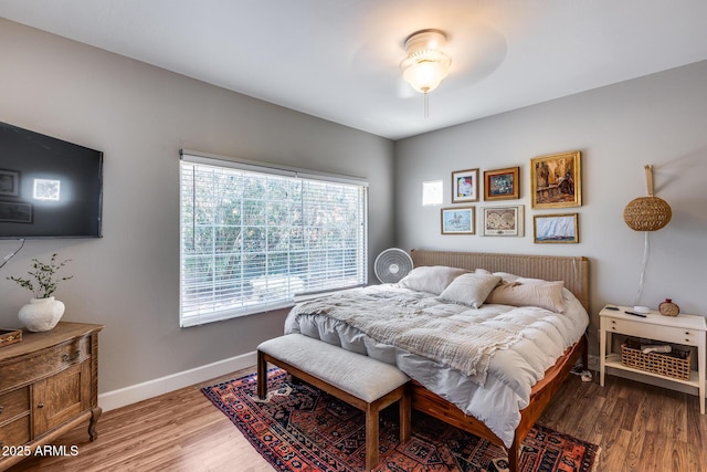 bedroom with baseboards and wood finished floors