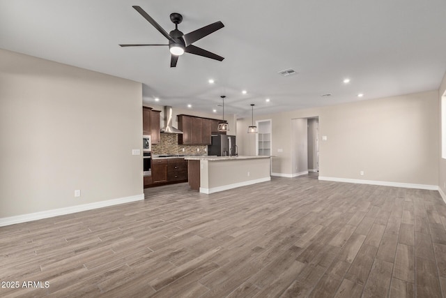 unfurnished living room with ceiling fan and light hardwood / wood-style floors