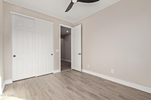 unfurnished bedroom featuring ceiling fan, light hardwood / wood-style floors, and a closet