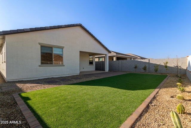 back of house with a yard and a patio area