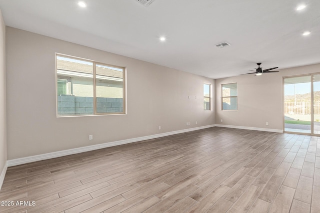 unfurnished room featuring ceiling fan, plenty of natural light, and light hardwood / wood-style floors